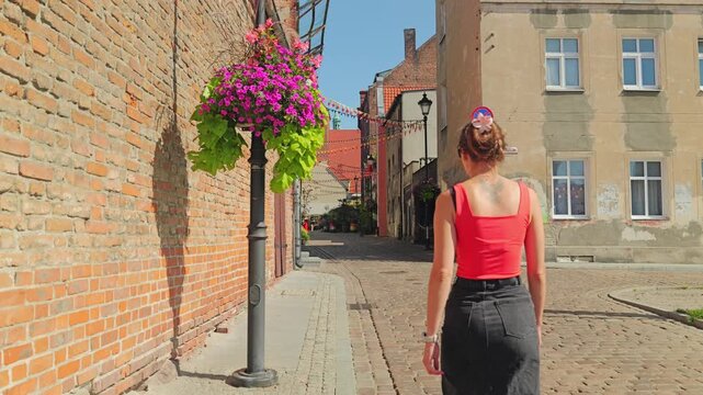 Charming old town atmosphere in Grudziadz with woman strolling cobbled streets