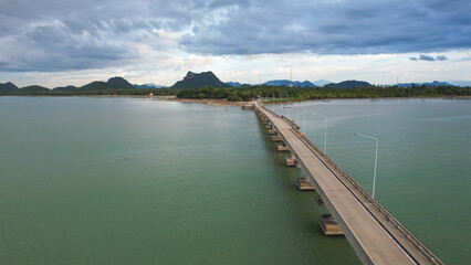 Obraz premium Aerial view of a road bridge leading to a small island and the village in the Gulf of Thailand