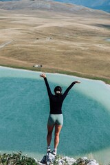 Obraz premium Woman on Cliff Overlooking Lake