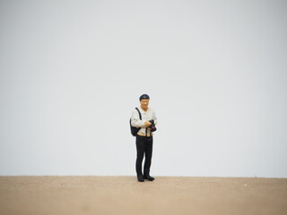 Mini toy of action figure at outdoor with blurred background. Miniature photography concept design. Minifigure of professional photographer.