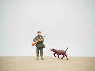 Fototapeta premium Mini toy of action figure at table with blurred background. Toy photography concept. Hunter man at outdoor concept. Adventure and explore people.