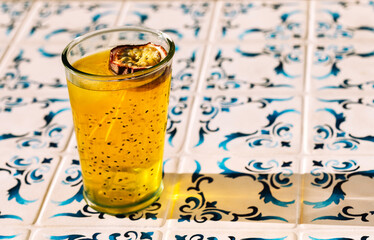 Close-up of a glass with a fresh healthy drink with passion fruit. Sweet juice with chia seeds