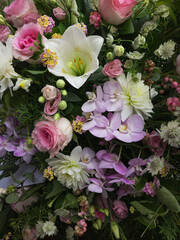 Draufsicht auf verschiedene Blüten im Blumenstrauß am Grab, zur Trauer