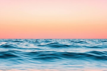 Naklejka premium Ocean waves rolling gently beneath a vibrant pink and orange sunset sky, creating a tranquil and serene seascape filled with beauty