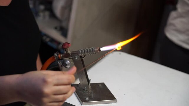 Jeweler making a glass bead with a small torch