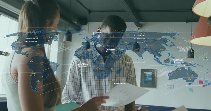 Girl offering datasheet to man in tech office as holographic world map expanding reviewing data