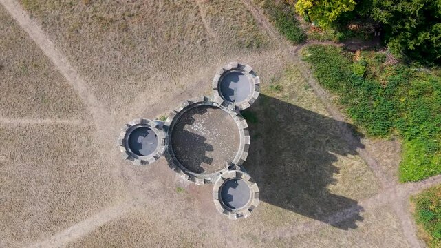 Aerial top-down drone view of Blaise Castle, Bristol, UK. The castle slowly rotates as shadows of its three turrets move clockwise, creating a striking time-like effect reminiscent of a giant clock.