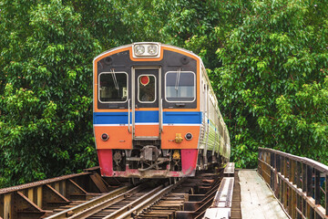 Obraz premium Train running in tree tunnel on the railway in Bangkok Thailand. focus at train