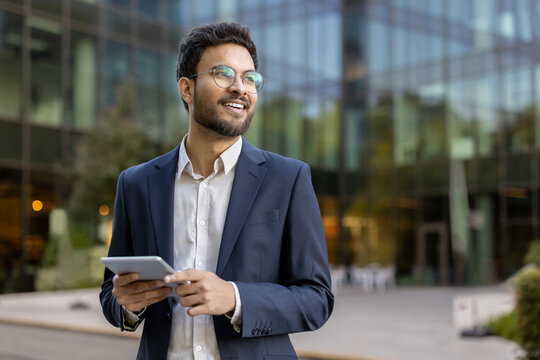 Confident business man using tablet near modern office building