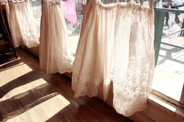 Cream-colored lace curtains hanging at a window