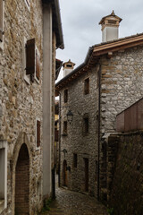 A stone alley in the mountain village of Poffabro, Friuli Venezia Giulia. The old houses and wooden roofs create an authentic and historic atmosphere.