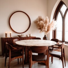 A stylish dining area featuring a round marble table, wooden chairs, and a large circular mirror, creating a warm and inviting atmosphere.