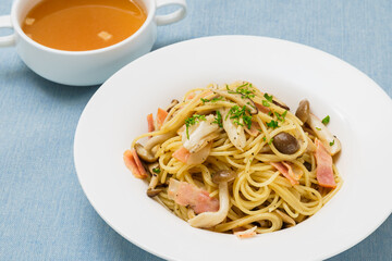 白い皿に盛り付けられたきのことベーコンのパスタのアップ写真
