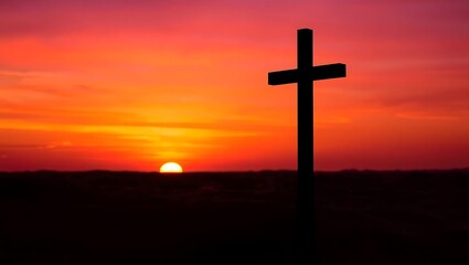 Silhouette of a cross against a vivid sunset sky with warm orange, pink, and purple hues, with the sun partially visible on the horizon and a peaceful, contemplative atmosphere