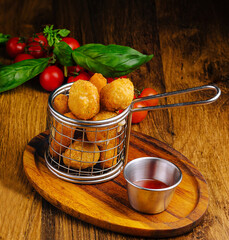 Delicious appetizer served in metal basket with dipping sauce and fresh herbs