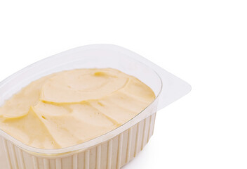 Closeup of mayonnaise sauce in transparent plastic container, isolated on white background, creamy condiment.