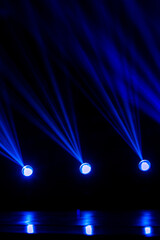 Blue theatre spotlights on a black background