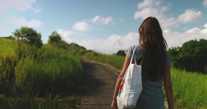 Young woman enjoys a peaceful walk along the campuhan ridge walk, a scenic trail in ubud, bali known for its lush greenery and stunning views