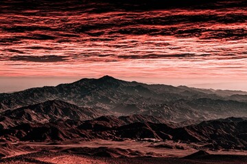 Dramatic mountain range panorama, fiery sunset clouds