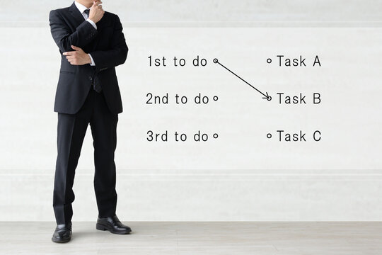 やるべき仕事の順位を考えるビジネスマンのイメージ画像