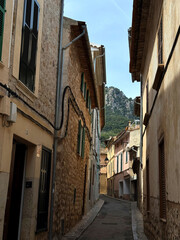 Fototapeta premium Narrow Mediterranean Street with Traditional Stone Houses and Mountain