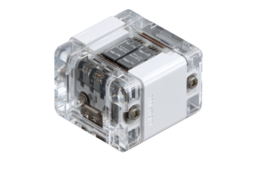 Clear acrylic cube, likely a microcomputer or electronic development board.  Internal components visible, including chips and circuitry.  White plastic accents and screws.  Compact and modular design