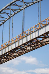 Bridge under construction showcasing metal structure and wooden supports in a serene landscape