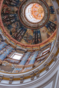 View of a dizzying upward gaze at a dome adorned with frescoes, framed by ornate gold trim and light filtering through windows, Alcal&Atilde;&iexcl; de Henares, Community of Madrid, Spain.