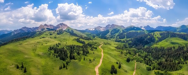 A breathtaking aerial view of lush green hills and majestic mountains under a bright blue sky with fluffy clouds.