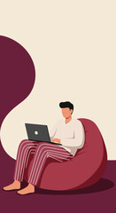 Man in casual wear comfortably working on his laptop from home, sitting on a bean bag. Illustrates flexible remote work and modern lifestyle.
