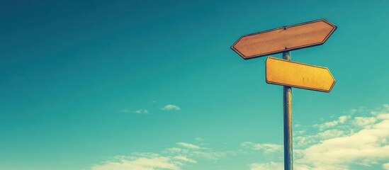A weathered wooden signpost with two blank directional arrows points against a vibrant blue sky dotted with fluffy clouds.