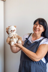 A cheerful woman, a skilled artisan, proudly displays her latest creation: a unique, meticulously...