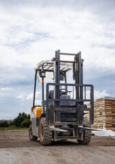 Forklift on a work site against a cloudy sky.