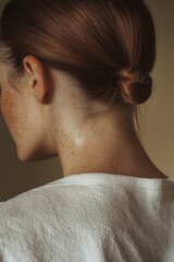 Close-up of a woman's neck and shoulders with dewy skin in soft lighting