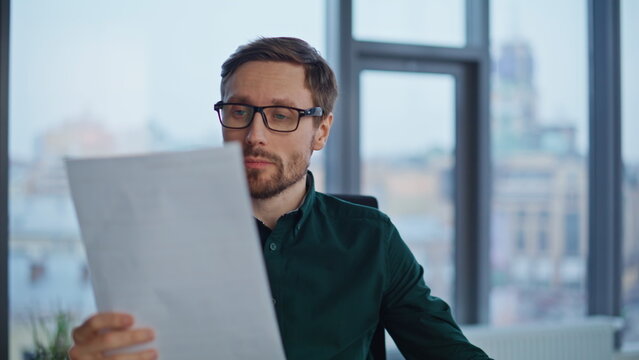 Serious startuper analyzing documents at workspace closeup. Stressed businessman