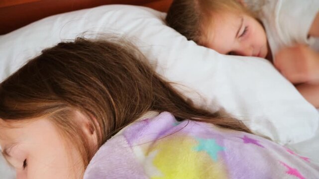 Caucasian two children sleeping in bed with white sheets. High angle shooting. Little sisters sleeping. Concept good night, restful sleep