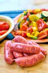 Raw Sausages, Grilled Vegetables on Cutting Board