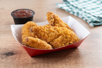 Crispy fried chicken tenders on wooden table