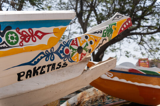Dakar, Senegal - 12 May 2025: View of colourfully painted prows of fishing boats docked at Soumb&Atilde;&copy;dioune beach, a vibrant display of local artistry against the sandy shore.
