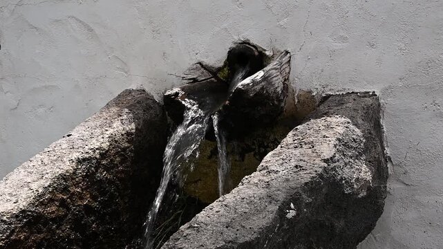 Agua fluyendo por canaleta de piedra antigua en La Palma