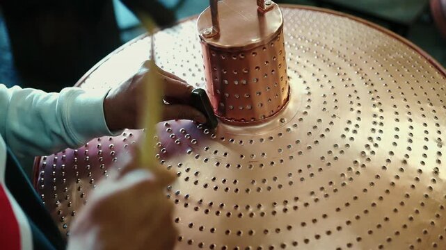 Traditional coppersmith workshop for copper brewing pots manufacturing. This handmade brewery kettles will be used for making traditional alcohol brandy drinks. Small traditional business concept