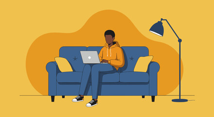 Young man working remotely on a laptop while comfortably seated on a sofa at home. Ideal for concepts of digital lifestyle, online learning, or casual business.