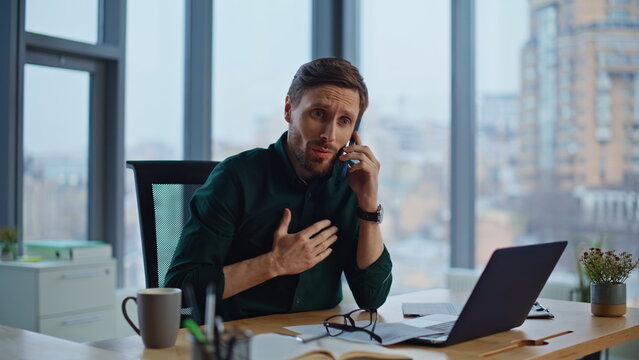 Business manager concerned call sitting workplace with panoramic window closeup.