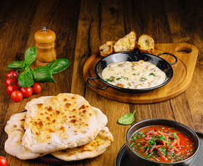 Delicious Indian meal with naan, curry, and fresh vegetables on wooden table
