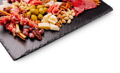 Assorted charcuterie and cheese platter on a slate board with nuts and olives