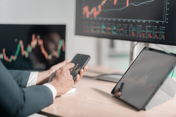 Businessman analyzes growth charts on laptop for financial insights using tablet and laptop to analyze financial charts. Investment strategies for near-term stock market growth