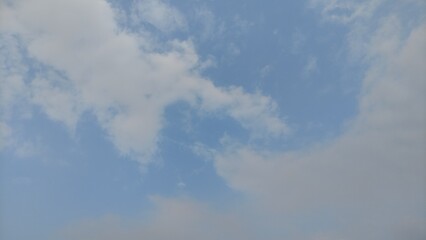 Slow moving white cumulus clouds. Blue sky with several layers of clouds.timelapse capturing soft, white clouds drifting peacefully against a bright blue sky. Perfect for stock footage, cinematic back