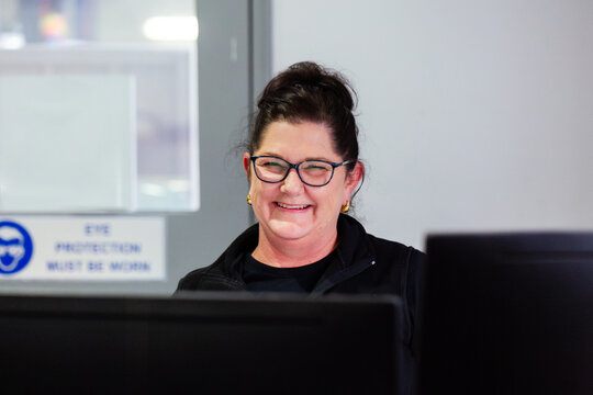 Female office staff portrait sitting in front computer screen smiling