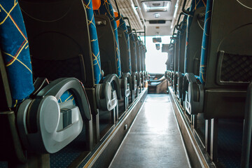 rows seats are lined up in modern bus, featuring vibrant blue fabric and ample legroom. bright...