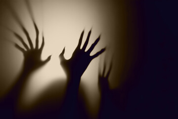  Shadow overlay effect for halloween background with Terrifying scary hands with long nails,Creepy monster claw,silhouette of hands,zombie hand rising out of a graveyard © Cool-Hunter